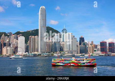 Farbenfrohe Fähre über Victoria Harbour und Skyline, Hongkong, China Stockfoto