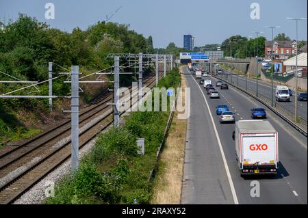 Eisenbahngleise entlang einer Straße in Salford, England. Stockfoto