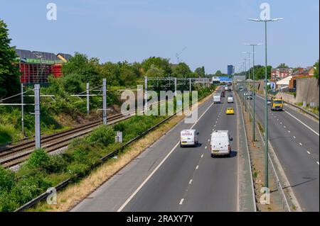 Eisenbahngleise entlang einer Straße in Salford, England. Stockfoto