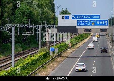 Eisenbahngleise entlang einer Straße in Salford, England. Stockfoto