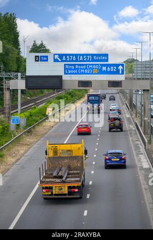 Eisenbahngleise entlang einer Straße in Salford, England. Stockfoto