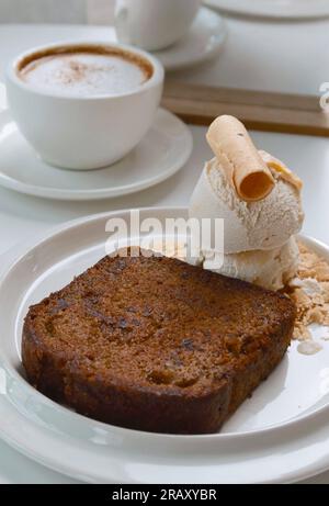 Schokoladen-Bananenkuchen und Vanilleeis mit heißem Kaffee Stockfoto