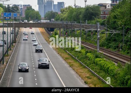 Eisenbahngleise entlang einer Straße in Salford, England. Stockfoto