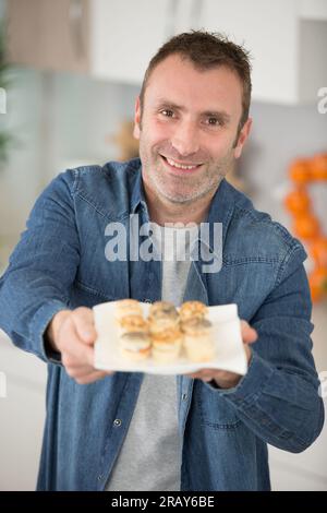 Ein Mann, der Tapas vor der Kamera zeigt Stockfoto