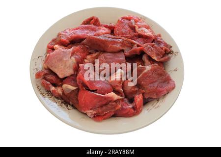 Fleischstücke auf einer Keramikschale, isoliert auf weißem Hintergrund. Rohes Rindfleisch zum Kochen. Draufsicht. Stockfoto