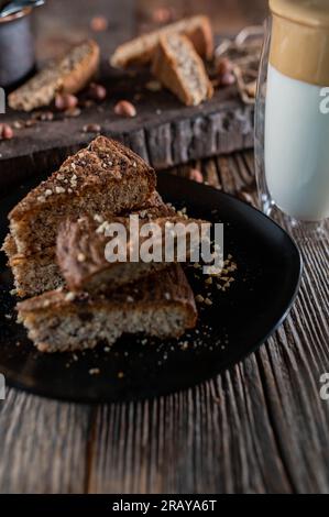 Nusskuchen mit Dalgona-Kaffee auf einem Holztisch Stockfoto