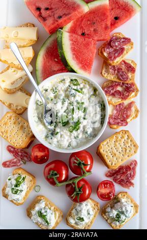 Vorspeise mit Wassermelone, Käse und Crackern auf weißem Teller Stockfoto