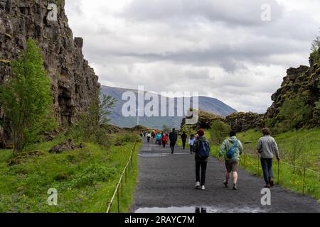 Thingvellir Rift Valley, Island - 06.26.2023: Touristen, die auf dem Kontinentalspalt zwischen der nordamerikanischen und eurasischen tektonischen Platte in Island spazieren Stockfoto