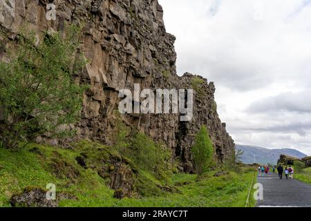 Thingvellir Rift Valley, Island - 06.26.2023: Touristen, die auf dem Kontinentalspalt zwischen der nordamerikanischen und eurasischen tektonischen Platte in Island spazieren Stockfoto