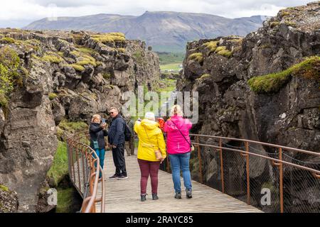 Thingvellir Rift Valley, Island - 06.26.2023: Touristen, die auf dem Kontinentalspalt zwischen der nordamerikanischen und eurasischen tektonischen Platte in Island spazieren Stockfoto