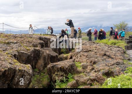 Thingvellir Rift Valley, Island - 06.26.2023: Touristen stehen auf dem Kontinentalspalt zwischen der nordamerikanischen und eurasischen tektonischen Platte auf Isländisch Stockfoto