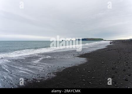 Wellen, die sich gegen Reynisfjara Black Sand Beach in Island wühlen Stockfoto