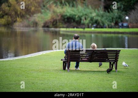 Ein Paar, das in einem Garten spaziert. Mann und Frau gehen in der Natur unter Bäumen, umgeben von Pflanzen. Familie zusammen in einem Park in Stockfoto