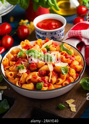 Pasta mit scharfer Tomatensoße, Parmesan und Basilikum. Pasta Chifferi Rigati. Stockfoto