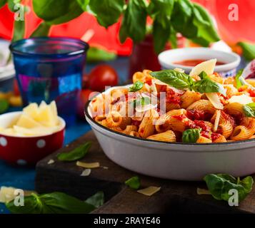 Pasta mit scharfer Tomatensoße, Parmesan und Basilikum. Pasta Chifferi Rigati. Stockfoto