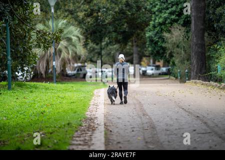 Ein Paar, das in einem Garten spaziert. Mann und Frau gehen in der Natur unter Bäumen, umgeben von Pflanzen. Familie zusammen in einem Park in Stockfoto