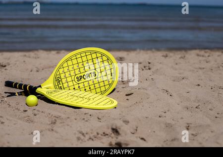 Beach Tennis Schläger und Ball am Strand Stockfoto