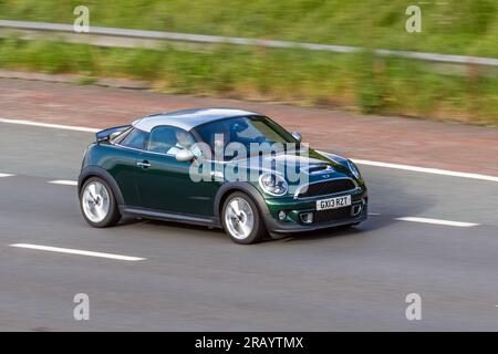 2013 Green Mini Cooper S Arrival, Start/Stop Car Coupe Benzinmotor 1598 ccm, Vordermotor, Vorderradantrieb, 2-Pass, 2-türige Heckklappe; Fahren mit hoher Geschwindigkeit auf der Autobahn M6 im Großraum Manchester, Großbritannien Stockfoto