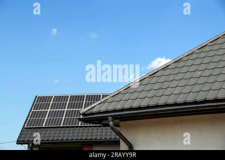 Hausdach mit Photovoltaikmodulen. Historisches Bauernhaus mit modernen Sonnenkollektoren auf Dach und Wand Hochwertiges Foto Stockfoto