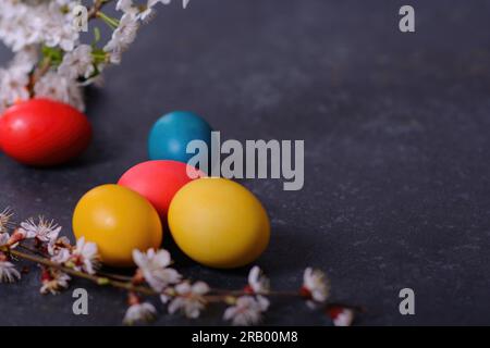 Frisch gebackenes hausgemachtes Osterbrot, natürlich gefärbte Eier und Frühlingsblumen. Stockfoto