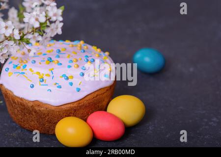 Frisch gebackenes hausgemachtes Osterbrot, natürlich gefärbte Eier und Frühlingsblumen. Stockfoto