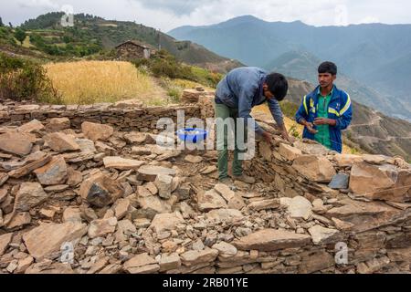 Juni 28. 2023, Nagthat, Uttarakhand, Indien. Einheimische Arbeiter bauen ein traditionelles Haus mit Stein in einem Dorf auf dem Land. Himalaya-Region UTT Stockfoto