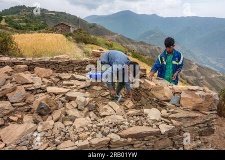 Juni 28. 2023, Nagthat, Uttarakhand, Indien. Einheimische Arbeiter bauen ein traditionelles Haus mit Stein in einem Dorf auf dem Land. Himalaya-Region UTT Stockfoto