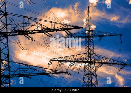 Elektrische Hochspannungsmasten gegen den Himmel mit dramatischen Wolken Stockfoto