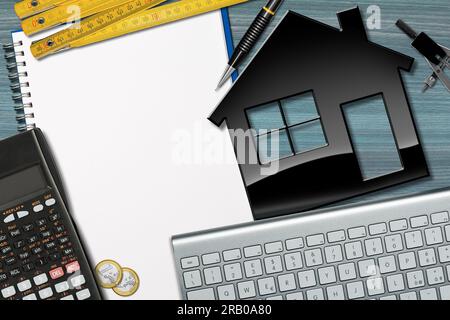 Kleines schwarzes Modellhaus auf einem Holzschreibtisch mit leerem Notizbuch (Spiralheft) mit Kopierraum, Taschenrechner, Lineal, Zeichenkompass, Euro-Münze Stockfoto