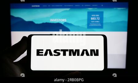 Person, die ein Smartphone mit dem Logo der US-amerikanischen Eastman Chemical Company auf dem Bildschirm vor der Website hält. Konzentrieren Sie sich auf das Display des Telefons. Stockfoto