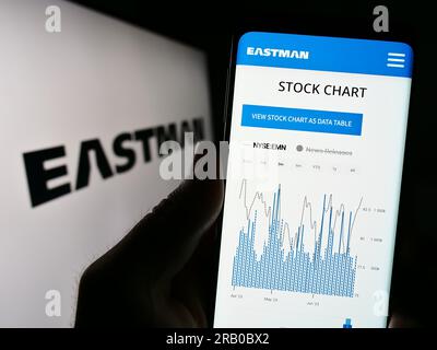 Person, die ein Mobiltelefon mit einer Website der US-amerikanischen Eastman Chemical Company auf dem Bildschirm vor dem Logo hält. Konzentrieren Sie sich auf die Mitte des Telefondisplays. Stockfoto