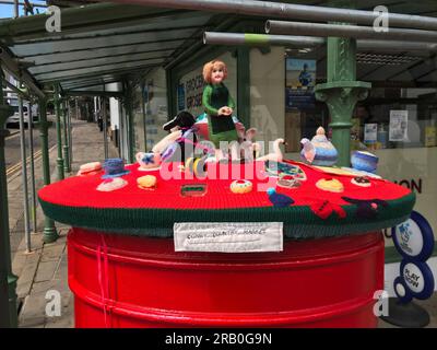 Briefkastenstrick/ gestrickte Briefkastenauflage feiert Waren und Menschen des Conwy Country Market, Conwy Square, North Wales lokale Kunst und Handwerk Stockfoto