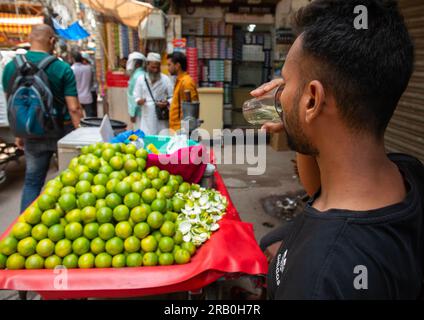 Ein indischer Mann trinkt Orangensaft in Alt-Delhi, Delhi, Neu-Delhi, Indien Stockfoto
