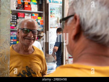 Lächelnder indianer, der eine Brille in einer Optik auswählt, Delhi, Neu-Delhi, Indien Stockfoto