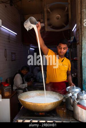 Indischer Mann, der Tee mit heißer Milch in Alt-Delhi, Delhi, Neu-Delhi, Indien einschenkt Stockfoto