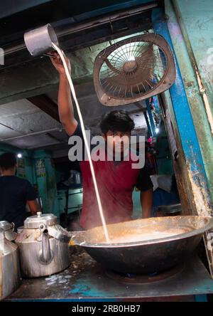 Indischer Mann, der Tee mit heißer Milch in Alt-Delhi, Delhi, Neu-Delhi, Indien einschenkt Stockfoto