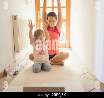 Mutter und Tochter machen zusammen Yoga Stockfoto