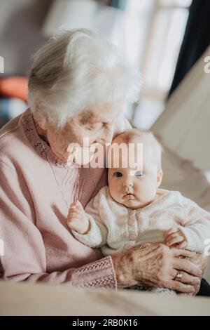 Urgroßmutter hält ihre Urenkelin in den Armen Stockfoto