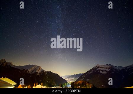 Österreich, Montafon, Garfrescha, Blick auf Schruns mit der Milchstraße. Stockfoto