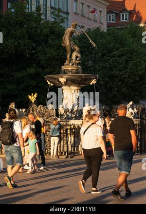 Touristen am Neptunbrunnen und der Statue als Wahrzeichen und Touristenattraktion in Dlugi Targ, Altstadt von Danzig, Polen Stockfoto