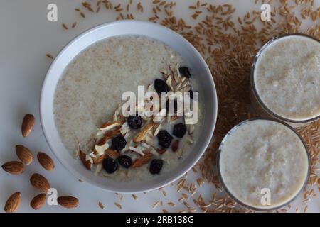 Khapli-Weizenbrei. Gesunder Haferbrei aus gebrochenem Emerweizen, in Milch gekocht und serviert mit Mandelscheiben und Rosinen. Eine Version von Haferbrei Stockfoto