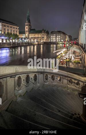 Nachtaufnahme im Jungfernstieg, Blick über die kleine Alster bis zum historischen Rathaus. Beleuchtete Stadt Hamburg, Deutschland Stockfoto