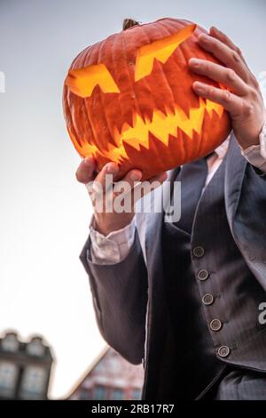 Spül-Maske, Halloween mit Kürbis. LED-Maske, gruseliger Mann. Corona, witzig, oktober, draußen. Urbane Szene Stockfoto