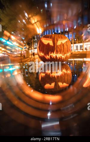 Spül-Maske, Halloween mit Kürbis. LED-Maske, gruseliger Mann. Corona, witzig, oktober, draußen. Urbane Szene Stockfoto