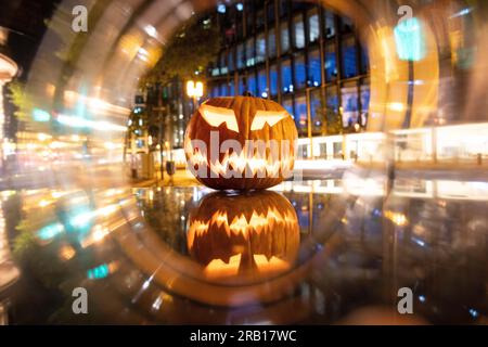 Spül-Maske, Halloween mit Kürbis. LED-Maske, gruseliger Mann. Corona, witzig, oktober, draußen. Urbane Szene Stockfoto