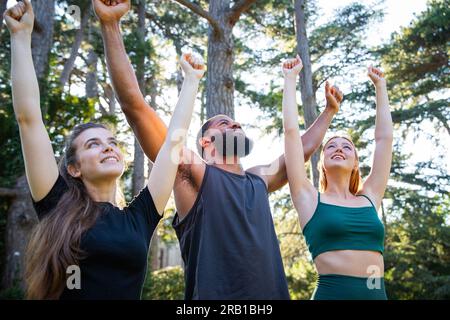 Eine Gruppe von Sportlern ist glücklich, wenn ihre Hände während des Trainings in der Luft gehoben werden, eine gesunde Lebensweise Stockfoto