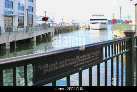 Metalltafel mit einem Zitat der Sopranistin Luisa Tetrazzini und der Yacht San Francisco Spirit, die am Pier 3 im Embarcadero San Francisco Kalifornien USA ankern Stockfoto