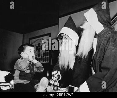 Chicago, Illinois: 14. November 1941 Ein Junge reagiert schockiert, wenn er zwei Weihnachtsklauseln sieht. Wie sich herausstellt, sind sie nur die Helfer des Weihnachtsmanns, die für die Freiwilligen Amerikas arbeiten. Stockfoto