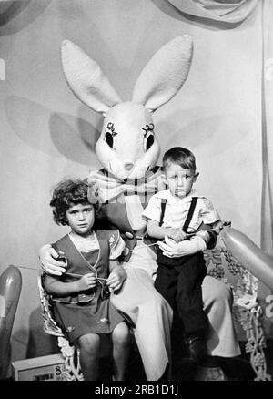 Vereinigte Staaten: 1950 zwei kleine Kinder in der Umarmung des Osterhasen. Stockfoto