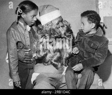 San Francisco, Kalifornien: 16. Dezember 1971 Ein Polizist, der als Weihnachtsmann verkleidet ist, sitzt mit zwei kleinen Kindern auf seinem Schoß. Stockfoto